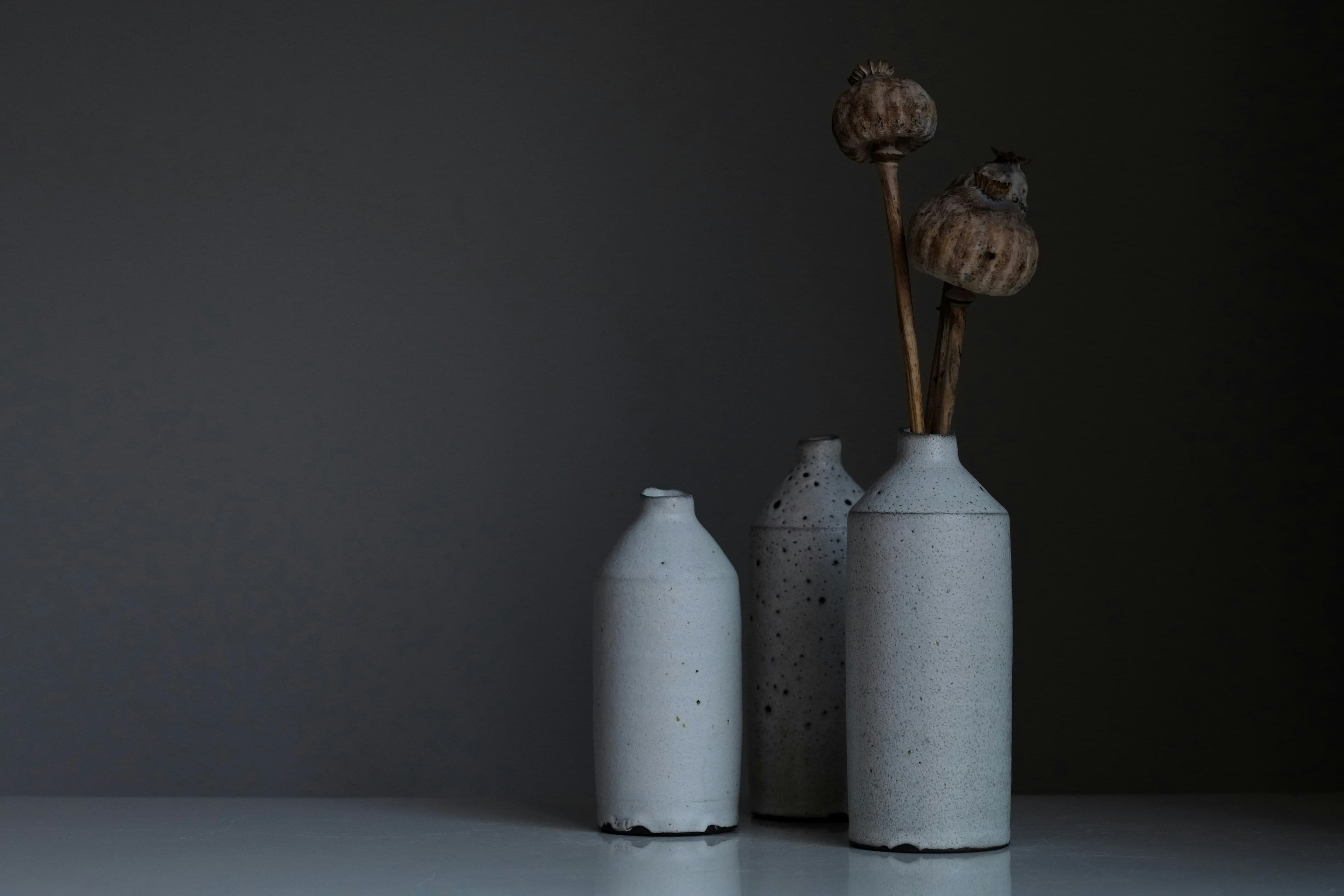 Three ceramic vessels on a shelf