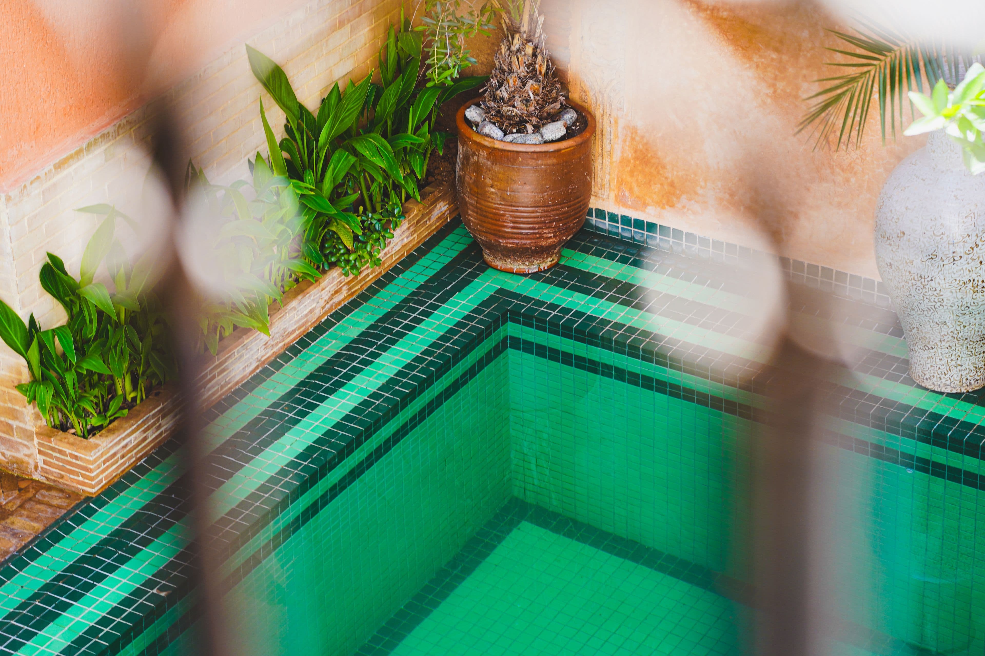 A peaceful pool and decorative tile details in a Marrakech riad