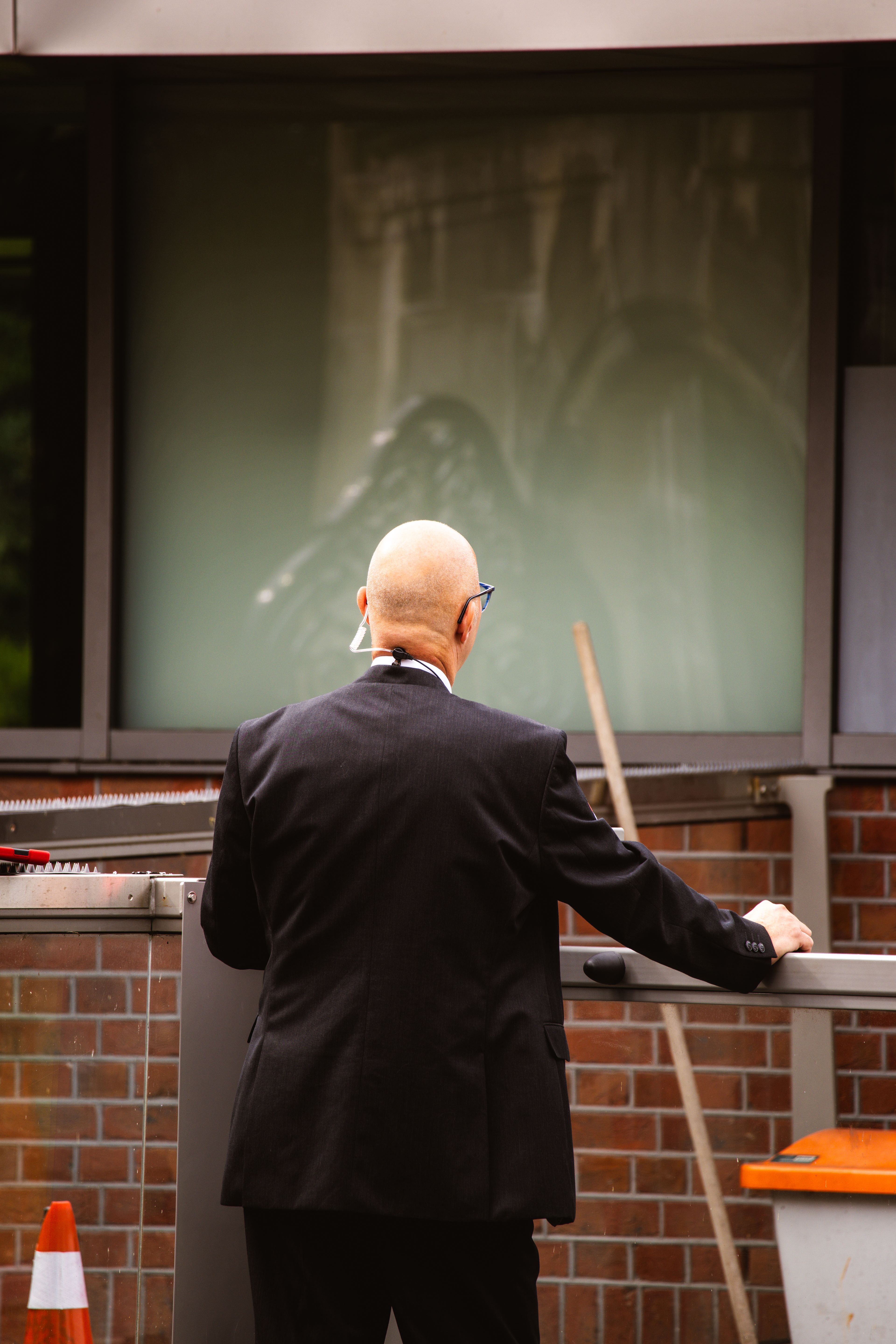 Suited security professional standing discreetly outside a building